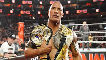 The Rock carrying the People's Championship handed to him by the family of Muhammad Ali during the WWE Hall of Fame 2024.