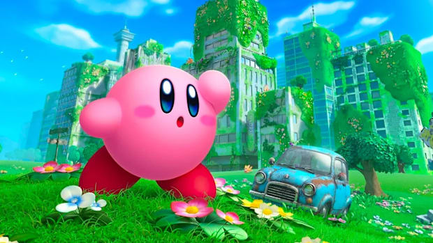 Kirby in a grassy field with a car behind him in Kirby and the Forgotten Land.