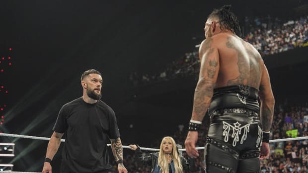 Finn Balor of The Judgment Day and Damian Priest stare down as Liv Morgan watches on during WWE Monday Night Raw.