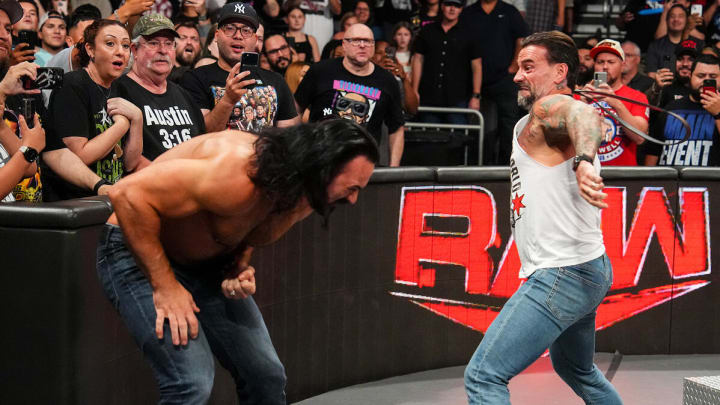 CM Punk attacks Drew McIntyre with his own belt during an episode of WWE Monday Night Raw.