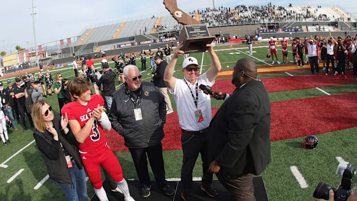 Palos Verdes coach Guy Gardner holds up trophy with his star sophomore QB Ryan Rakowski looking on. Palos Verdes coach Guy Gardner holds up trophy with his star sophomore QB Ryan Rakowski looking on.