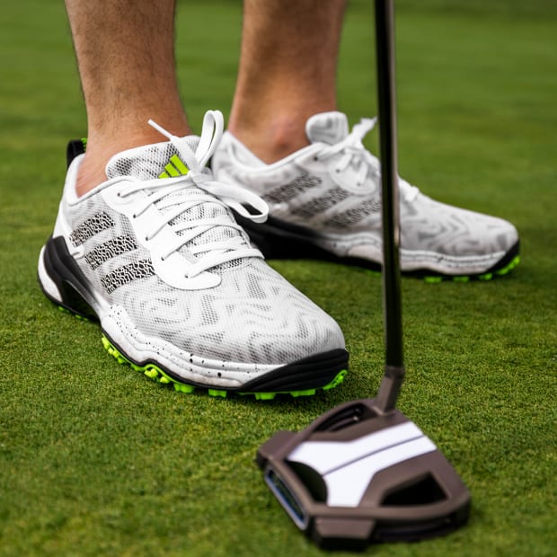 White and black adidas golf shoes.