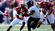 Miami Redhawks running back Kevin Davis (8) runs by Cincinnati Bearcats defensive tackle Dontay Corleone (2) in the first quarter of the College Football game at Yager Stadium in Cincinnati on Saturday, Sept. 14, 2024.