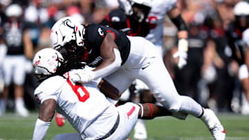 Cincinnati Bearcats defensive lineman Marquaze Parker (98) tackles Houston Cougars wide receiver Devan Williams (8) in the second quarter of the College Football game at Nippert Stadium in Cincinnati on Saturday, Sept. 21, 2024.