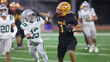 Mission Viejo's Phillip Bell tries to shed a De La Salle defender during the 2023 CIF D1-AA state title game