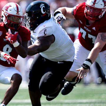 Miami Redhawks running back Kevin Davis (8) runs by Cincinnati Bearcats defensive tackle Dontay Corleone (2) in the first quarter of the College Football game at Yager Stadium in Cincinnati on Saturday, Sept. 14, 2024.