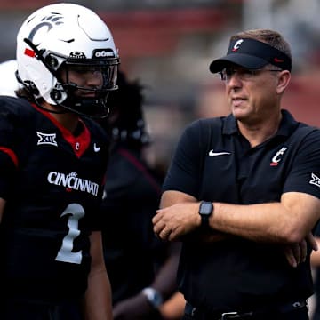 Cincinnati Bearcats head coach Scott Satterfield speaks with Cincinnati Bearcats quarterback Brendan Sorsby (2) before the College Football game between the Cincinnati Bearcats and the Houston Cougars at Nippert Stadium in Cincinnati on Saturday, Sept. 21, 2024.