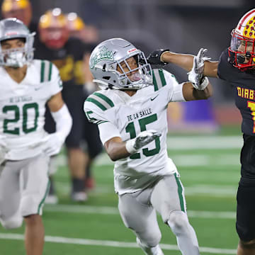 Mission Viejo's Phillip Bell tries to shed a De La Salle defender during the 2023 CIF D1-AA state title game