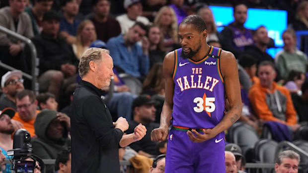 Kevin Durant speaking with Suns' coach Mike Budenholzer during a game