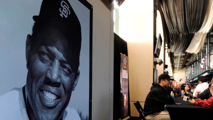 San Francisco Giants' catcher Buster Posey answers questions during World Series Media Day next to a portrait of Giants great Willie Mays, Tuesday, October 26, 2010.
