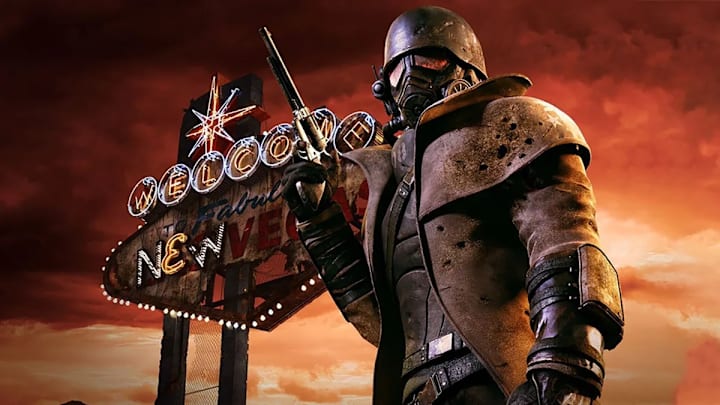 The main character poses against the Vegas sign, wearing a helmet and a duster jacket, holding a revolver, in Fallout NV