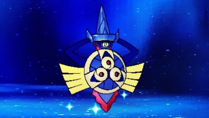 A sword Pokemon with tassles that act as arms, tucked into a shield. The entire thing is a metallic black with red highlights