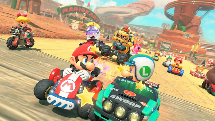 Mario and Luigi bumping their karts together with a chaotic race going on in the background in Mario Kart World.
