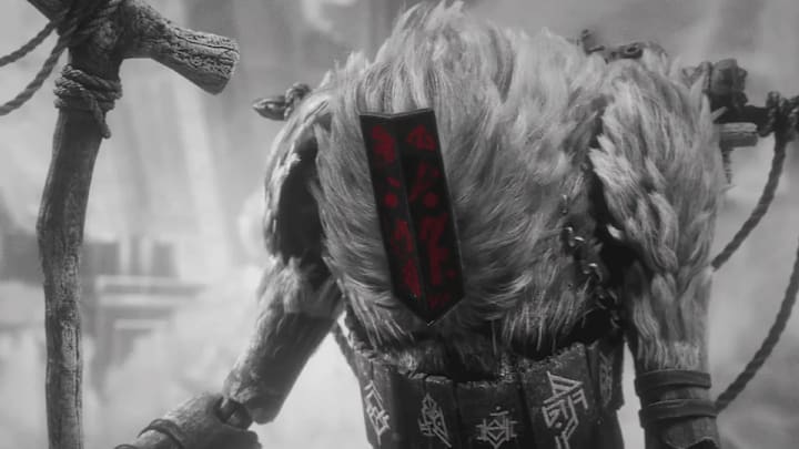 A humanoid creature with white fur and red markings on his mask carrying a large stick.