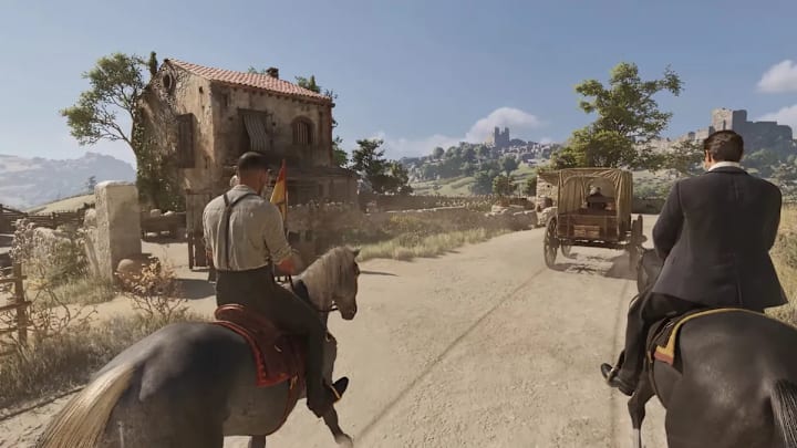 Two men riding down a dirt path in Sicily on horseback.