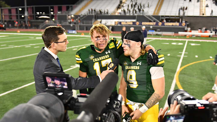Edison star players Jake Minter (left) and Julius Gillick speak on live television after the victory ceremony of the Chargers' 21-14 victory of Central in Saturday's CIF Division 1-A title game at Saddleback College. 