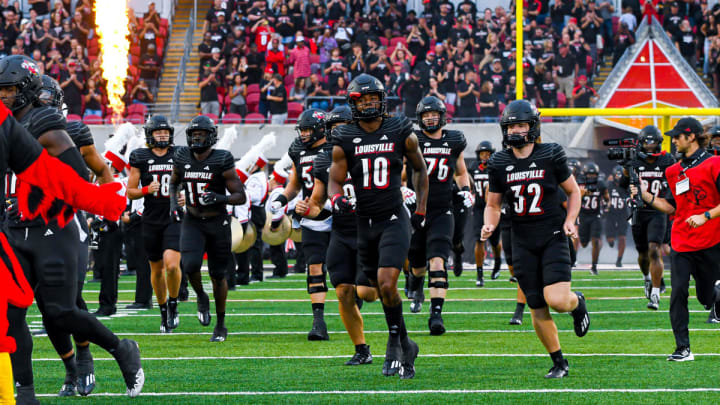 Louisville players running onto the field of L&N Stadium during pregame.