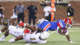 Duncanville fights for yardage through two South Oak Cliff tacklers in 2023 Texas high school football.