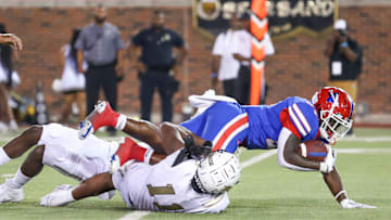 Duncanville fights for yardage through two South Oak Cliff tacklers in 2023 Texas high school football.