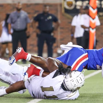 Duncanville fights for yardage through two South Oak Cliff tacklers in 2023 Texas high school football.