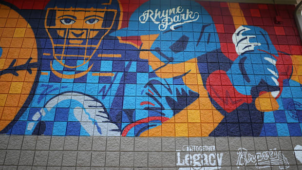 Mural painting of softball images on a wall in Rhyne Park.