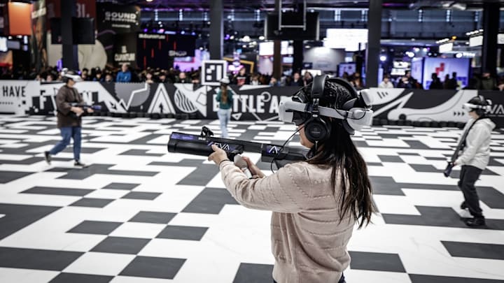 Visitantes participan en un juego virtual durante la Semana de Juegos en París.