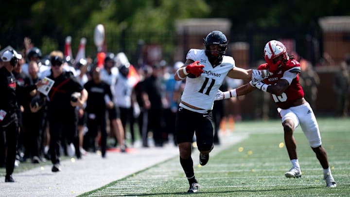 Cincinnati Bearcats tight end Joe Royer (11) stiff arms Miami Redhawks linebacker Oscar McWood (23) before the play is called back for holding in the fourth quarter of the College Football game at Yager Stadium in Cincinnati on Saturday, Sept. 14, 2024.