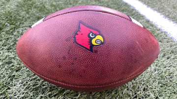A football sporting the Louisville Cardinals logo