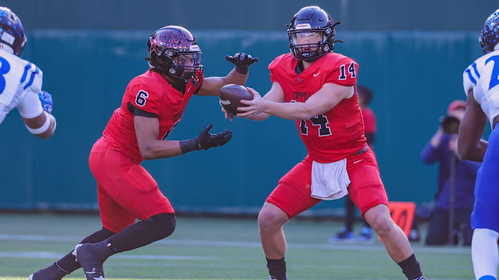Coppell QB Eddie Griffin hands off to Omarion Mbakwe in a 2023 Texas high school football game.