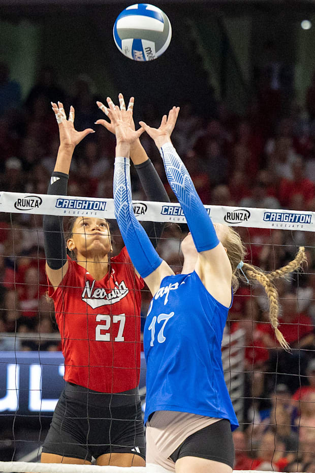 Nebraska outside hitter Harper Murray and Creighton setter Annalea Maeder prepare to joust at the net after a Bluejay overpas