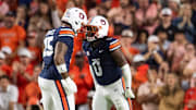 Auburn Tigers linebacker Robert Woodyard Jr. (0) celebrates his sack with defensive end Keldric Faulk.