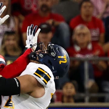 Sep 7, 2024; Tucson, Arizona, USA; Arizona Lumberjacks quarterback Ty Pennington (6) throws the ball against Arizona Wildcats defensive lineman Tre Smith (3) during first quarter at Arizona Stadium