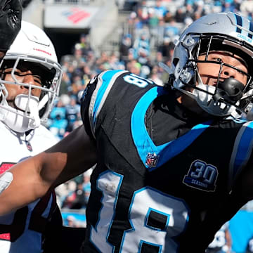 Dec 22, 2024; Charlotte, North Carolina, USA; Carolina Panthers wide receiver Jalen Coker (18) attempts to catch the ball in the end zone as Arizona Cardinals safety Jalen Thompson (34) defends in the first quarter at Bank of America Stadium.
