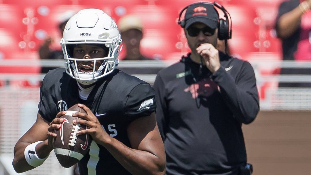 Arkansas Razorbacks quarterback KJ Jackson (7) rolls out to pass during the spring game at Razorback Stadium as coach Ryan Silverfield observes.