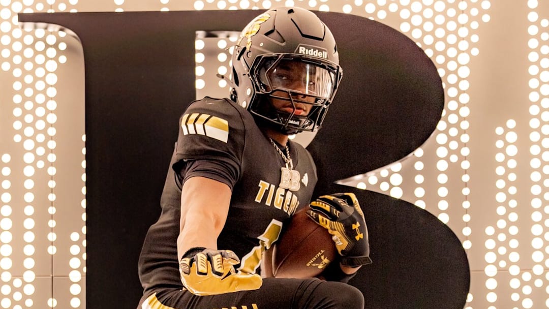Junior defensive back Bryson Brown with the Heisman Trophy pose after announcing his decision to transfer to Broken Arrow High School in Oklahoma.