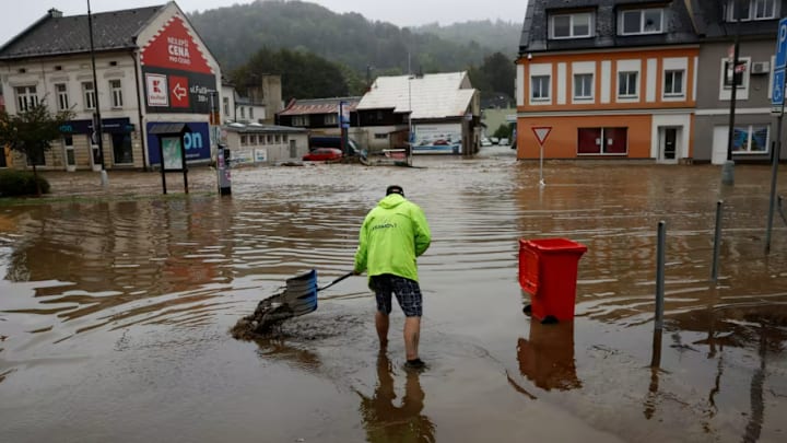 A man shovels debris in floodwater following heavy rainfall in Jesenik, Czech Republic, on Sept. 15, 2024.