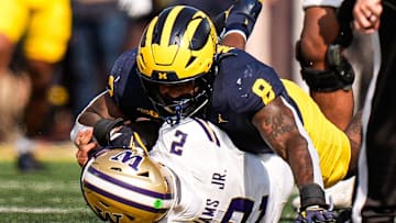 Michigan edge Derrick Moore (8) sacks Washington quarterback Demond Williams Jr. (2) during the first half at Michigan Stadium in Ann Arbor on Saturday, Oct. 18, 2025.