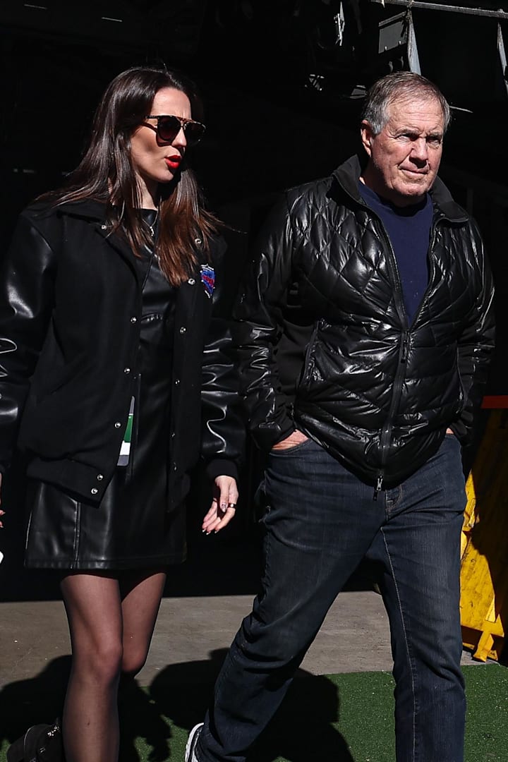 Former New England Patriots head coach Bill Belichick and girlfriend Jordon Hudson enter the field before a game. 