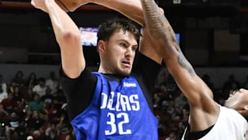 Jul 12, 2025; Las Vegas, NV, USA; Dallas Mavericks forward Cooper Flagg (32) passes the ball against San Antonio Spurs center Nathan Mensah (31) and guard Dylan Harper (2) in the third quarter of their game at Thomas & Mack Center. Mandatory Credit: Candice Ward-Imagn Images