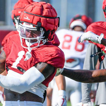 Arkansas Razorbacks defensive back Kee'yon Stewart hangs to an interception in individual drills Monday morning on the practice fields in Fayetteville, Ark.