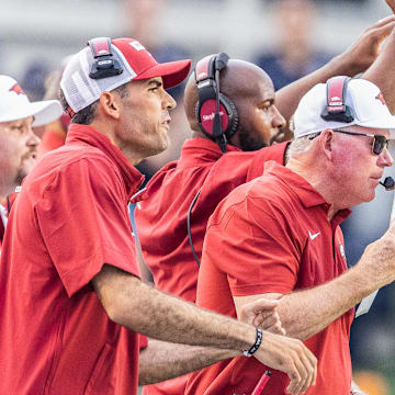 Arkansas Razorbacks coach Bobby Petrino using play sheet to cover crowd noise on microphone against UAPB in Little Rock.