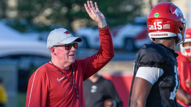 Razorbacks offensive coordinator Bobby Petrino coaching fine points of throwing motion with left-handed quarterback KJ Jackso