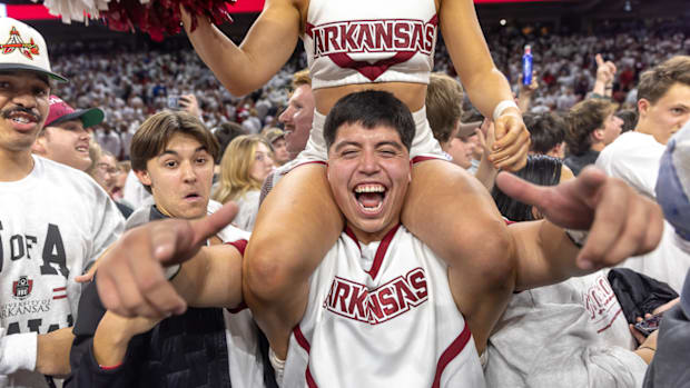 Razorbacks cheerleaders and fans rush the court at Bud Walton Arena after a win over Duke