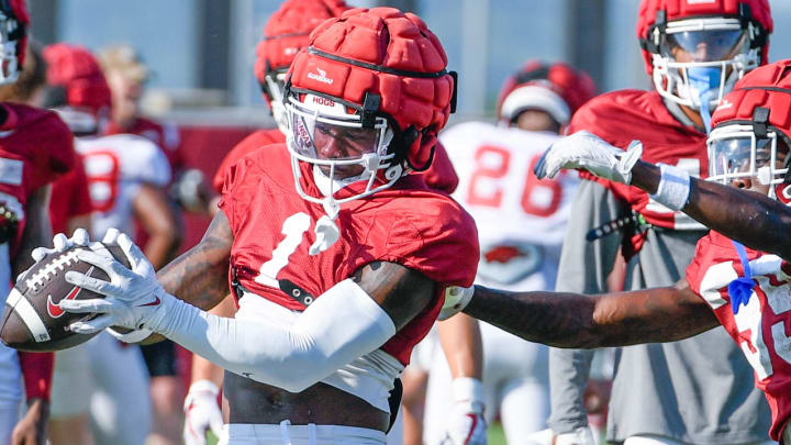 Arkansas Razorbacks defensive back Kee'yon Stewart hangs to an interception in individual drills Monday morning on the practice fields in Fayetteville, Ark.