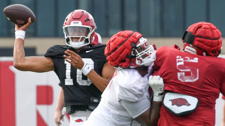 Arkansas Razorbacks quarterback Taylen Green attempts a pass as defensive lineman Cam Ball rushes in a fall camp practice in Fayetteville, Ark.