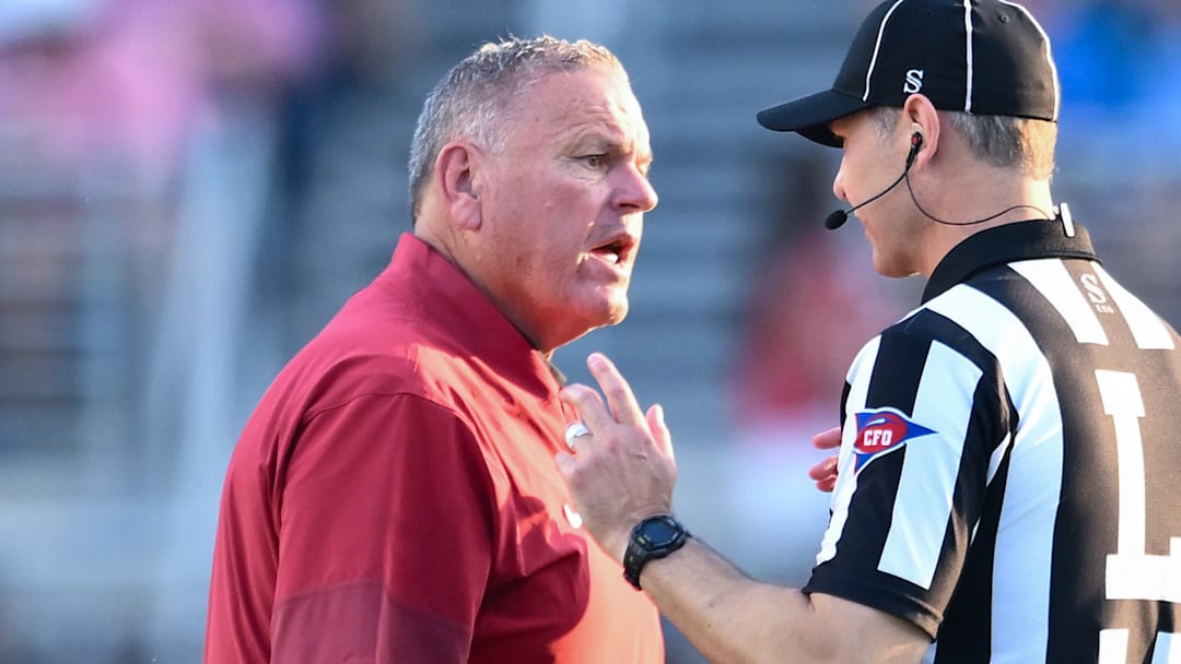 Arkansas Razorbacks coach Sam Pittman discussing a call with an official in a game against the Ole Miss Rebels at Vaught-Hemingway Stadium in Oxford, Miss.