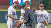 Arkansas Razorbacks pitcher Zach Root has equipment and his hand looked in a game against the Texas Longhorns at Baum-Walker Stadium in Fayetteville, Ark.