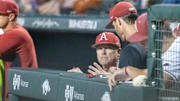 Arkansas Razorbacks coach Dave Van Horn talking with pitching coach Matt Hobbs in the dugout in a game against the Texas Longhorns at Baum-Walker Stadium in Fayetteville, Ark.