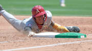 Arkansas Razorbacks shortstop Wehiwa Aloy diving back to first base against the Tennessee Volunteers in a Super Regional game at Baum-Walker Stadium in Fayetteville, Ark.