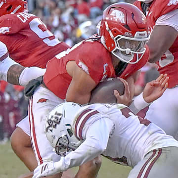 Arkansas Razorbacks quarterback Taylen Green tackled by a Mississippi State defender during a game at Razorback Stadium in Fayetteville, Ark.